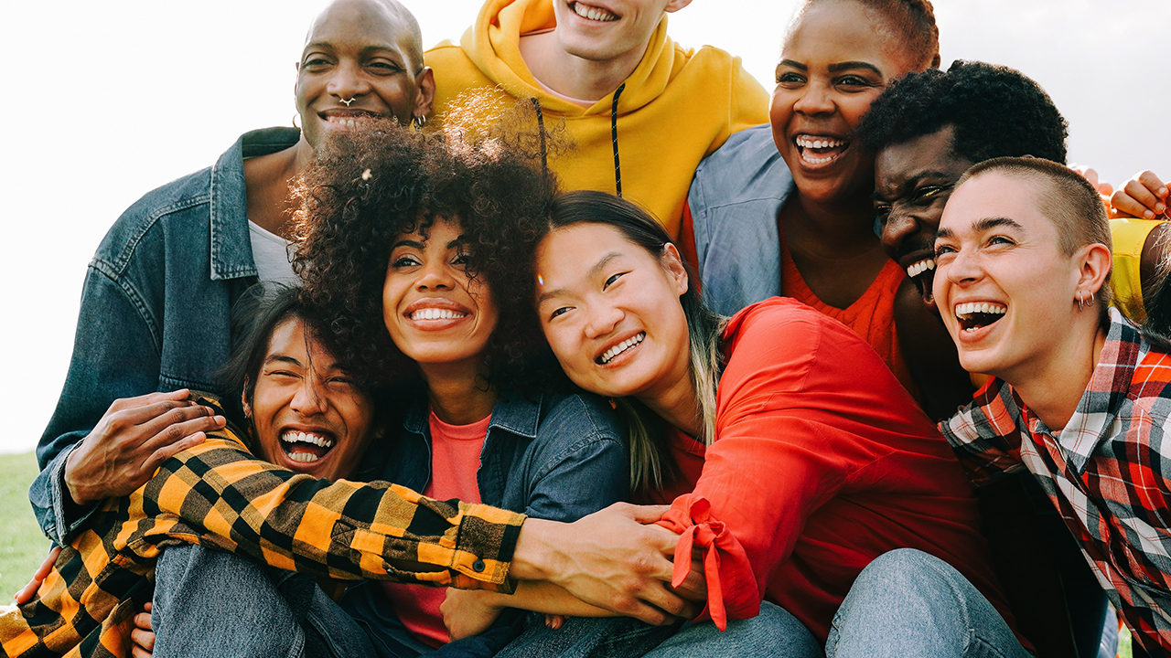 A group of young people engage in a group hug