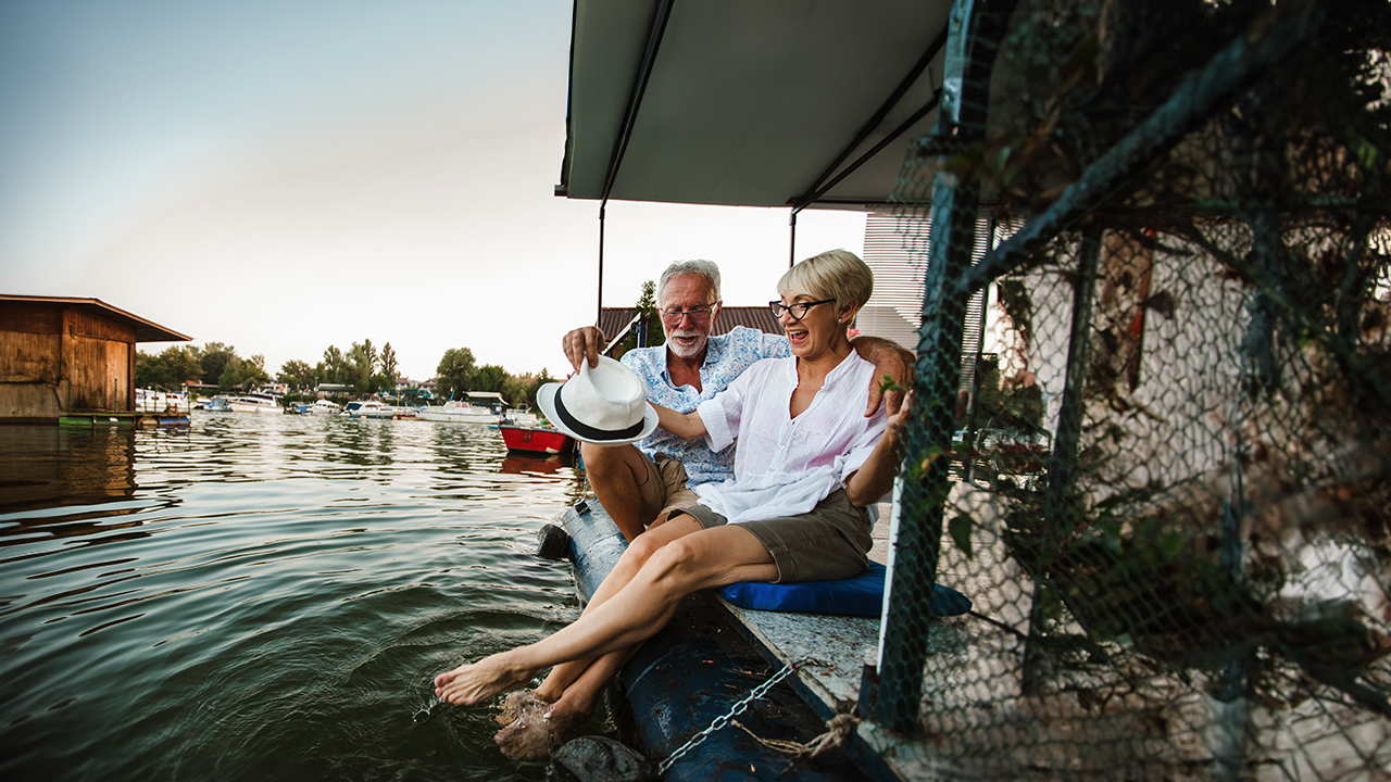 An older couple enjoys sitting by the water